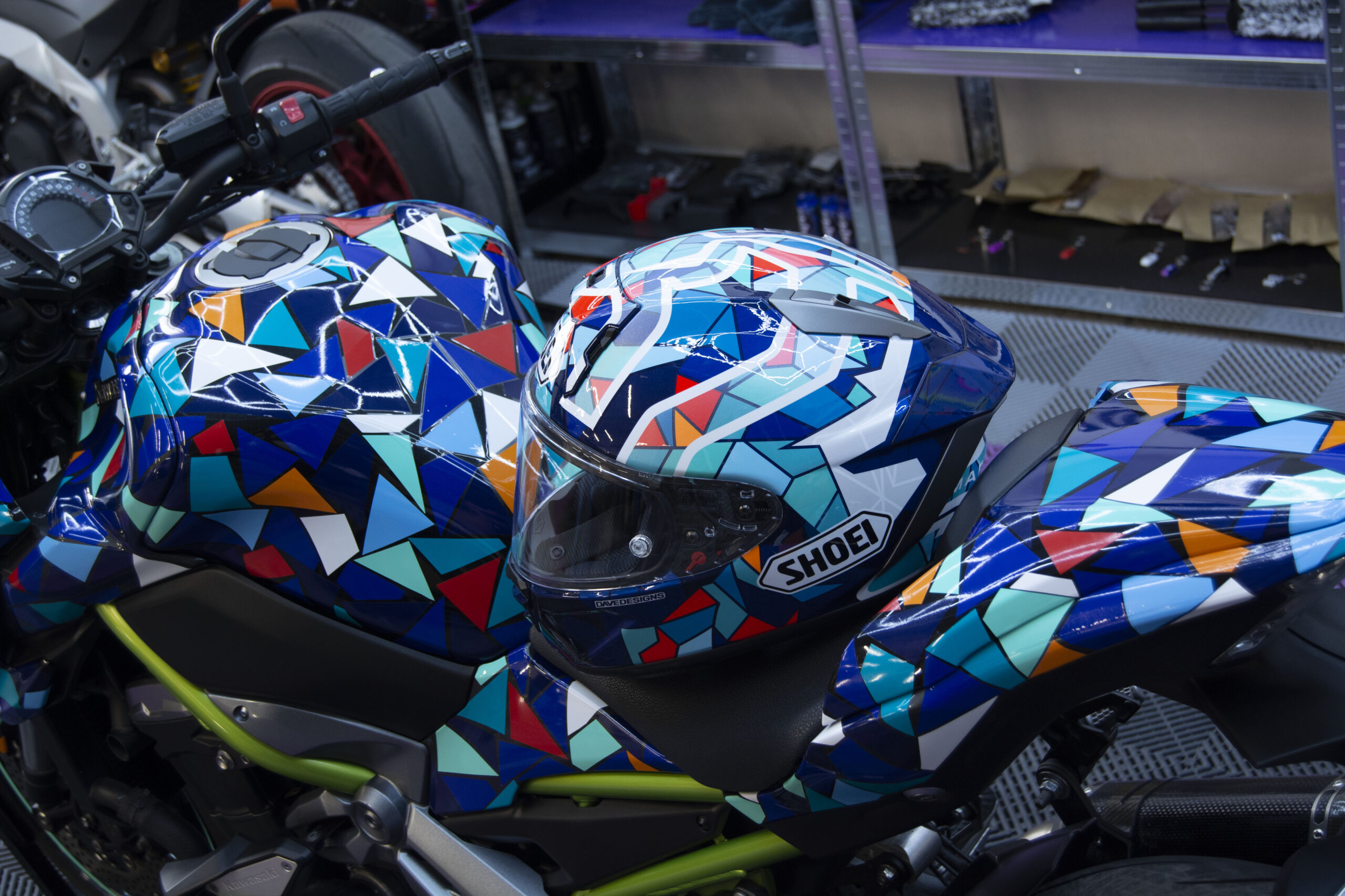 Casco con diseño colorido sobre una moto vinilada
