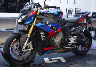 Moto naked BMW con carenado negro, azul y rojo en el taller de 977 Graphics